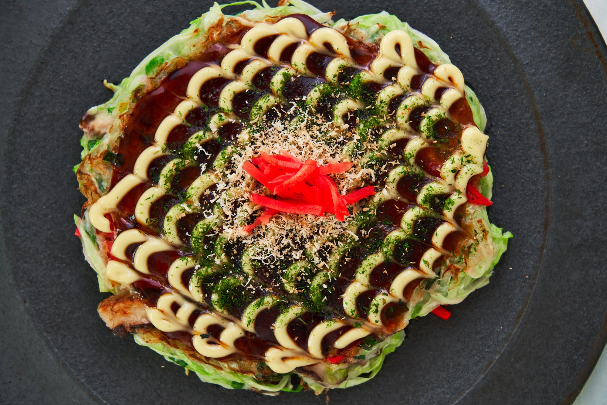 This delicious plant-based Okonomiyaki is loaded with cabbage, scallions and shiitake mushrooms.