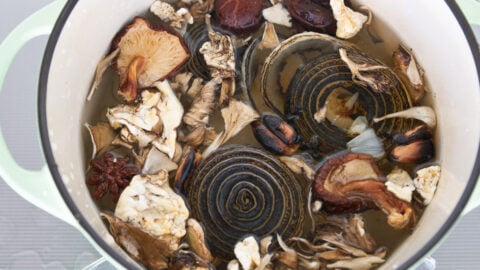 Dried shiitake and maitake mushrooms with charred aromatics and spices for making vegan pho broth.