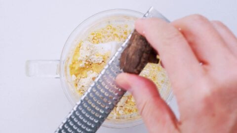 Grating dried shiitake mushrooms into a powder.