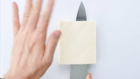 Slicing frozen tofu in half.